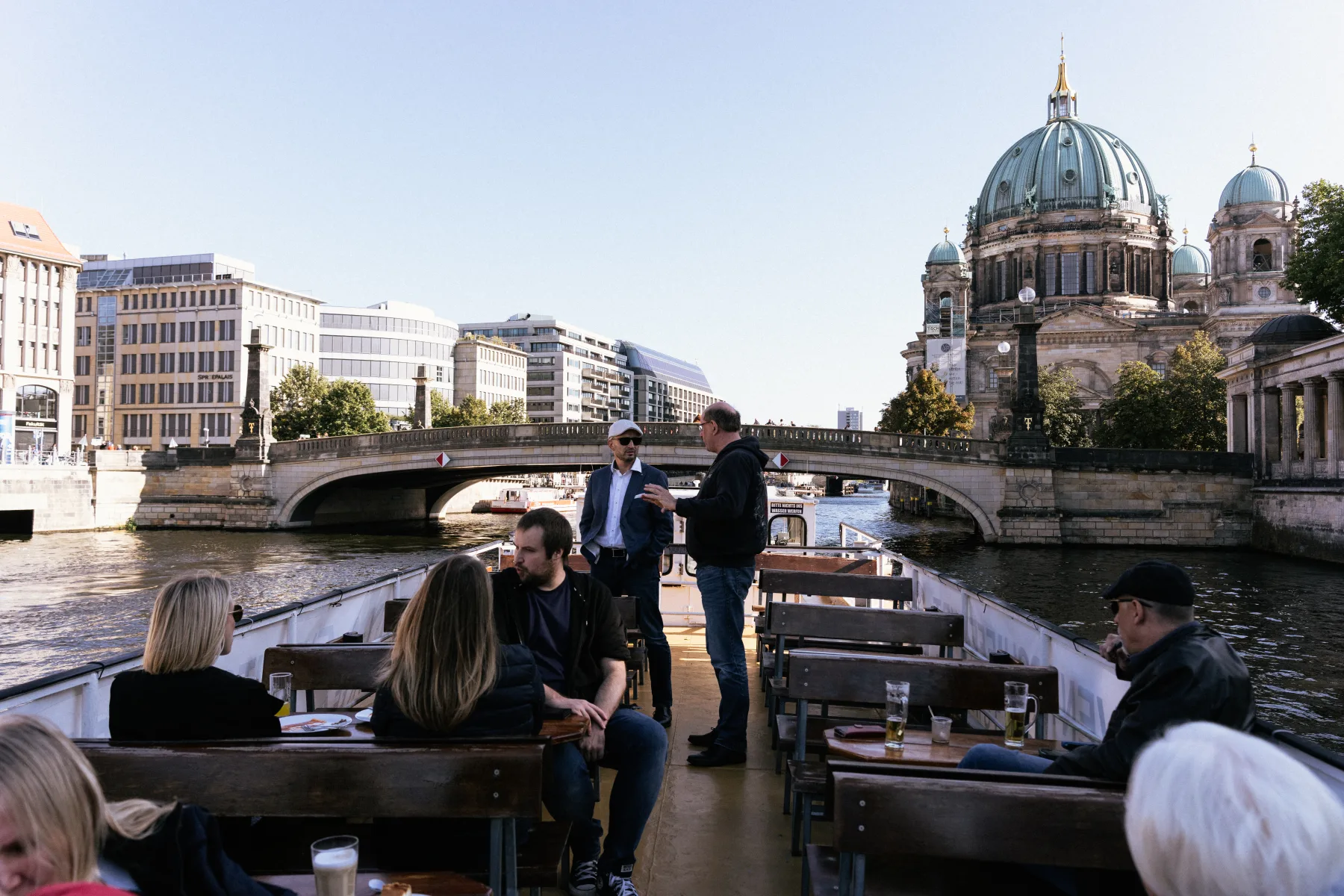 Gäste mit Getränken auf dem Oberdeck eines Schiffs der Reederei Böttcher auf der Spree